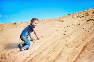 Girl plays among the sand
