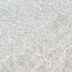 Shining blue water at sea. Summer and travel concept. Neutral background with sun reflection. Top view, flat lay.