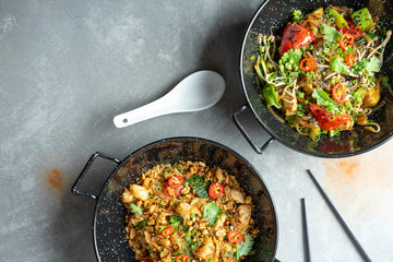 top view on Pad thai and pho noodle. Flat lay pan-asian food with copy space. Traditional asian street food. stir-fried rice noodle. Spicy cuisine. Grey stone background. Menu or banner