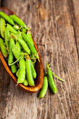 Green peas in a wooden bowl.