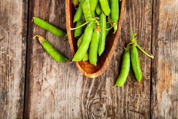 Green peas in a wooden bowl.