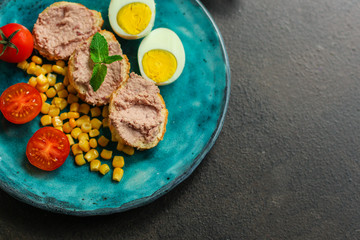 Breakfast snack, tasty food (pate, toast, tomato, corn, egg, coffee). top view. food background