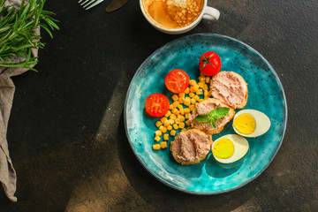 Breakfast snack, tasty food (pate, toast, tomato, corn, egg, coffee). top view. food background