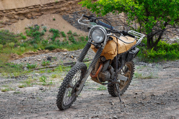 The steampunk motorcycle stands on the stony ground without rider