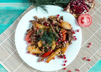 Baked veal with tomatoes decorated with herbs and pomegranate fruits natural color background