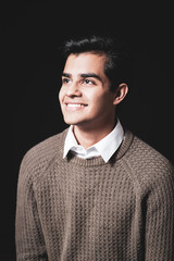 Junger Mann sympathisch lachend vor schwarzem Hintergrund 