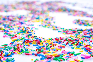 Colorful candy sprinkles close up for birthday cake on white background