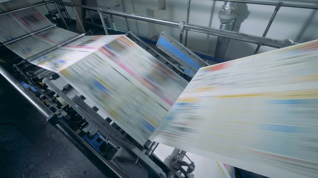 Working conveyor moves printed newspaper in a typography facility.