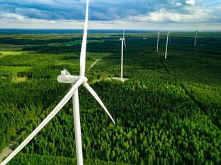 Aerial view of windmills in summer forest in Finland. Wind turbines for electric power with clean and Renewable Energy © NBLX