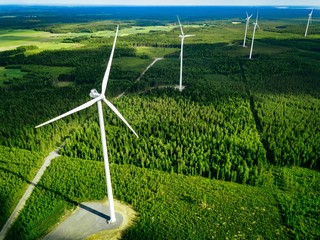 Fototapety  Widok z lotu ptaka wiatraków w lesie latem w Finlandii. Turbiny wiatrowe na energię elektryczną z czystą i odnawialną energią