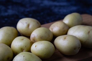 Raw potatoes on dark background. Selective focus.