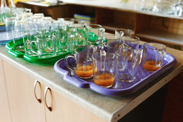 Stacks of cups of finished meal after lunch waiting to clean at the dining room in camp.