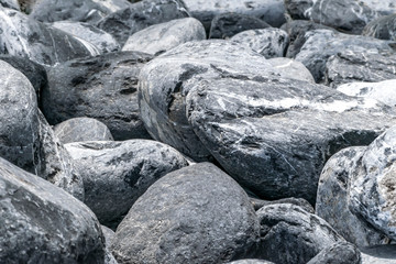 Gray and white large pebbles stone pile background. Natural environmental decorative material. Stone fence or wall