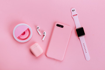 Up to date technology.Top view of diverse personal accessory laying on the pink background