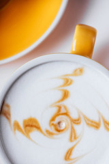 Cup of hot cappuccino coffee with cake on white table with copy space