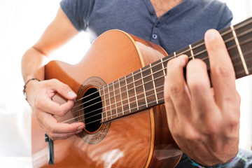 Fototapeta na wymiar man's hands playing acoustic guitar, close up