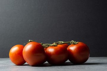 Fresh organic red tomatoes on dark background. Selective focus.