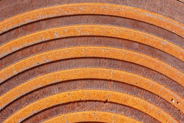 part of a rusty iron door with an oval strips