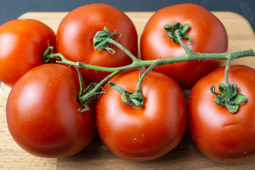 Fresh organic red tomatoes on dark background. Selective focus.