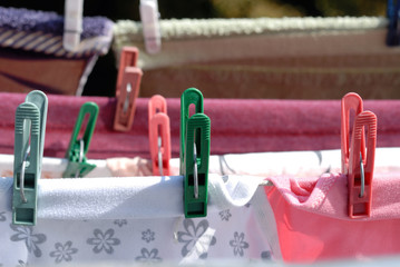 Clothes are dried attached with clothespins to the ropes