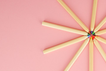 Fototapeta premium Pink background with wooden colorful ordinary pencils. Back to school.