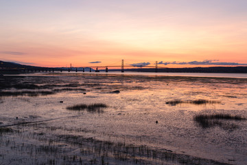Naklejka premium Horizontal view of the 1935 Island of Orleans Bridge over the St. Lawrence River seen from the Beauport area of Quebec City during a summer sunrise, Quebec, Canada