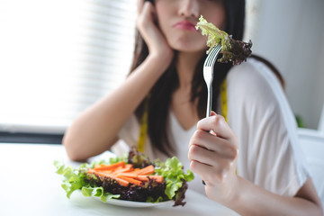 The girl has a boring expression when she eats vegetables. She wants to eat delicious food. Diet,...