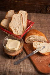 Naklejka premium Bakery - gold rustic crusty loaves of bread and buns on black chalkboard background. Still life captured from above