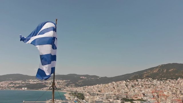 Greek flag waving in slow motion in Kavala city