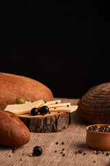 Slices of cheese on wooden desk between different breads. place for text