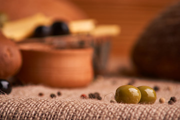 olive is on the table in background of bread, baguette and cheese. Selective focus