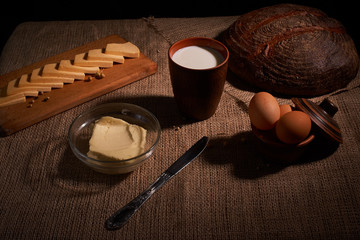 Assorted dairy products milk, cheese, eggs. rustic still life on table