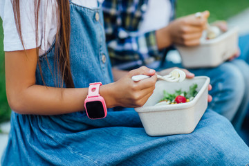 Close up photo, focus at smart watches on kids hands. After school with healthy eat.