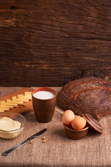 Assorted dairy products milk, cheese, butter rustic still life on table