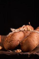 Two Fresh baguettes on dark wooden table. Selective focus