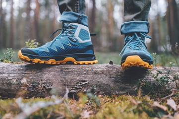 Male legs wearing sportive hiking shoes outdoor. Mens legs in trekking boots for outdoor activity