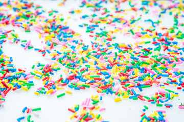 Fototapeta na wymiar Colorful candy sprinkles close up for birthday cake on white background