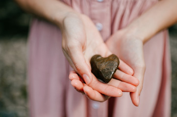 Female hands holding stone looking like heart - Powered by Adobe