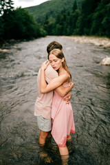 Lifestyle loving couple hugging in the river