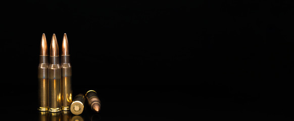 Bullet isolated on black background with reflexion. Rifle bullets close-up on black back....
