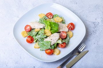 Caesar (cesar) salad with chicken, crackers, parmesan and cherry tomatoes. Close-up.