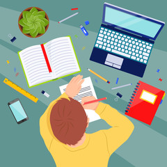 Child at the table with school supplies doing homework. Student with a pencil in his hands. Study concept