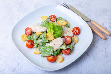 Caesar (cesar) salad with chicken, crackers, parmesan and cherry tomatoes. Close-up.