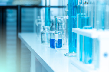 Laboratory glassware equipment and science experiments with Chemical formula. Laboratory glassware containing chemical liquid. Science research, background and concept in blue tone.