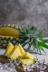 Pineapple cocktail or juice with ice and pineapples on a dark background