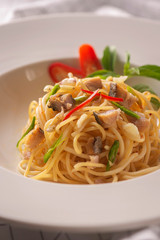 Salted fish spaghetti served in a white dish