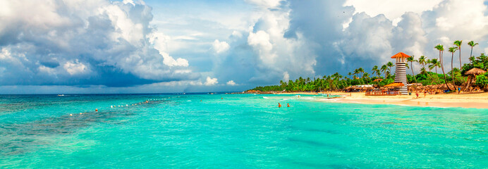 Obraz na płótnie Canvas Panoramic view of the tropical beach with lighthouse in Dominican Republic. Coconut Palm trees on white sandy beach.