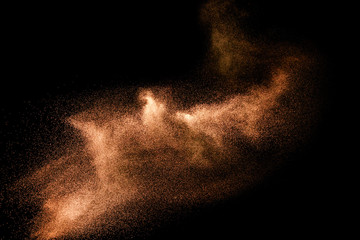 Abstract sand cloud.Brown sand splash against dark background. Brown dust explosion. - obrazy, fototapety, plakaty