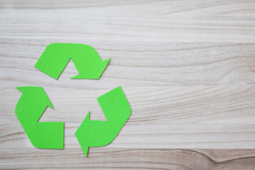 Reciclable symbol on a wooden background with space for adding text