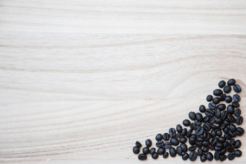 Coffe beans on the corner of a natural wooden background, with space to add text